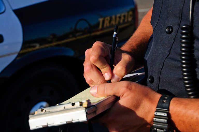 writing a ticket by traffic officer