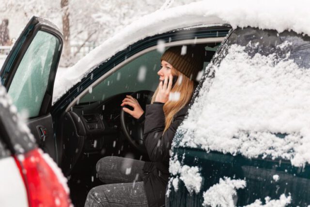a woman in a car with snow on her face