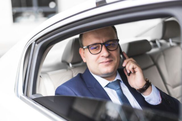 man on the phone in the back of a rideshare vehicle