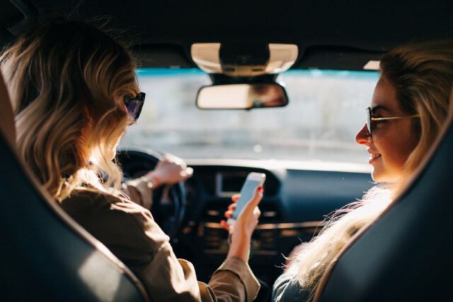 two woman friends driving together