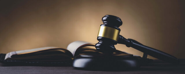Justice and law concept. Judges gavel and law book on the table, toned image