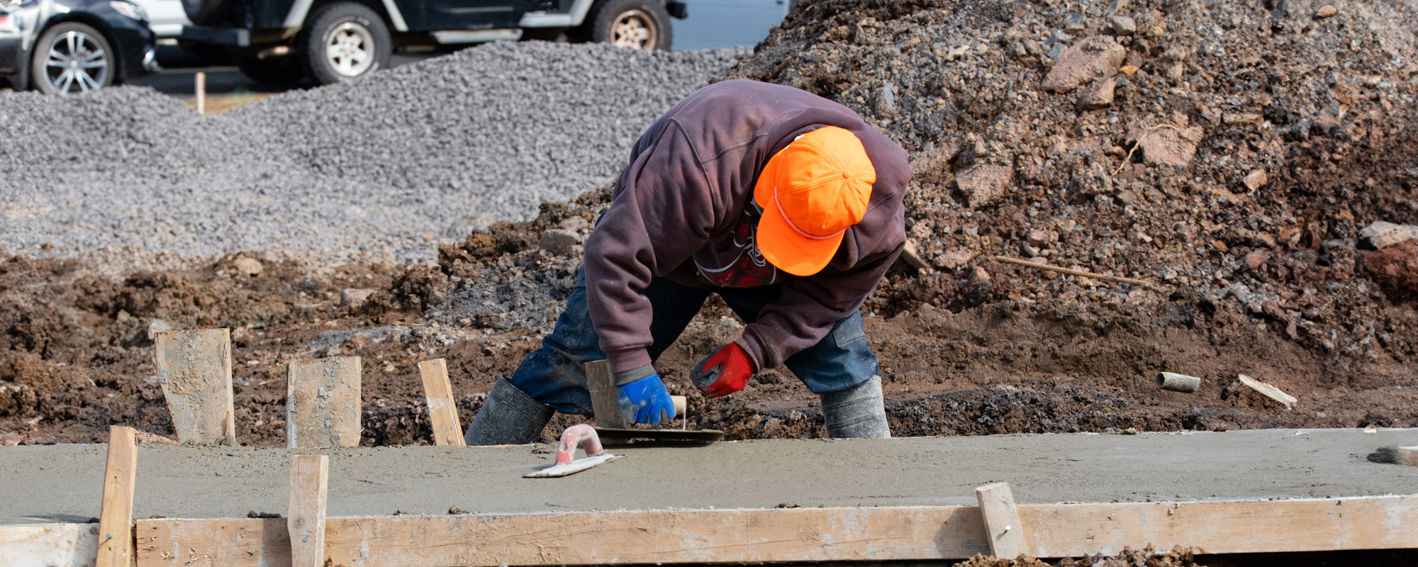 construction worker leveling concrete pavement outdoors