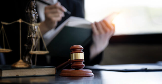 Wooden gavel on desk with lawyer working on background, copy space, banner and background.